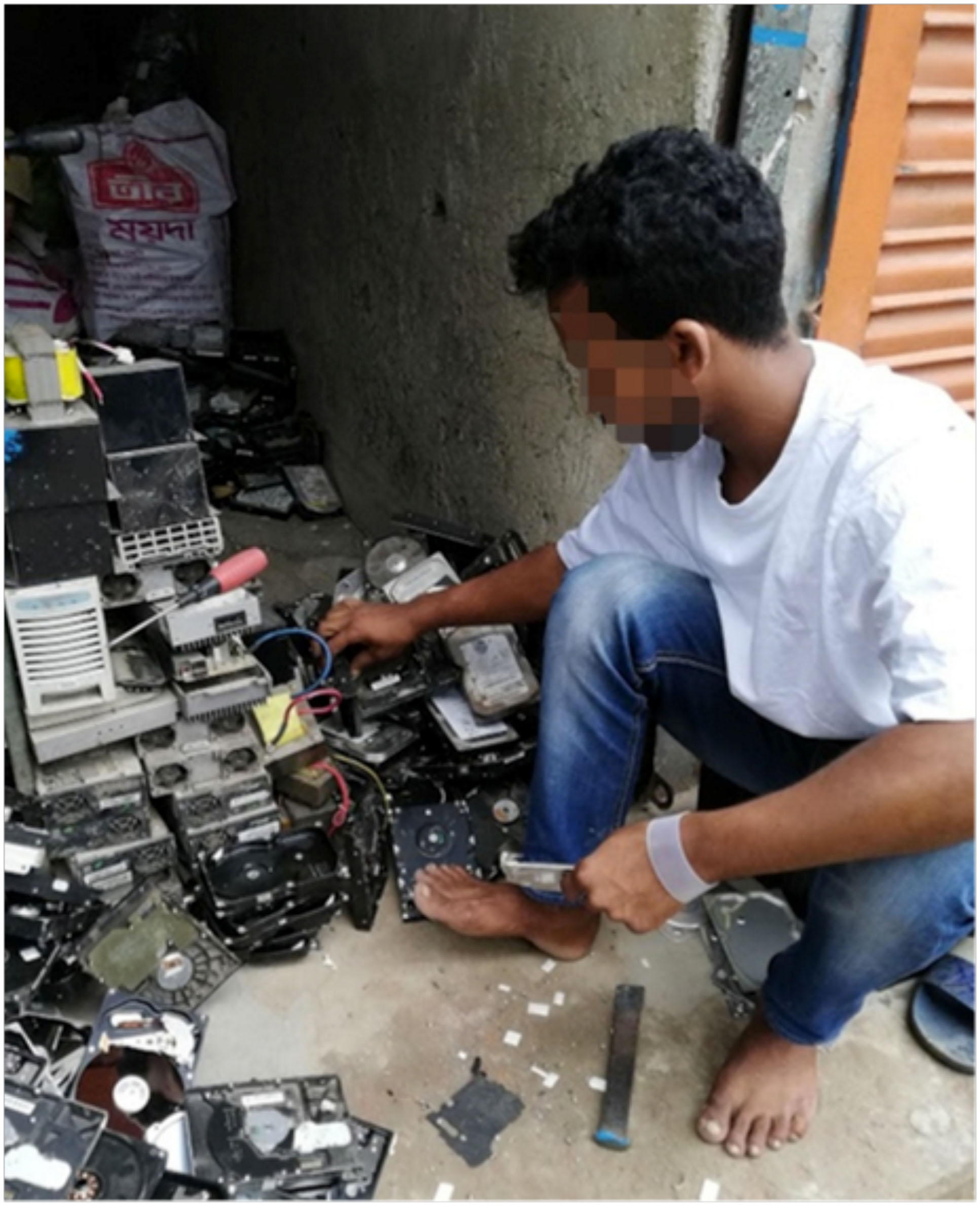 Treballador de desmantellament de residus electrònics a Bangla Desh, amb la samarreta i la polsera de silicona utilitzades en l'estudi.
